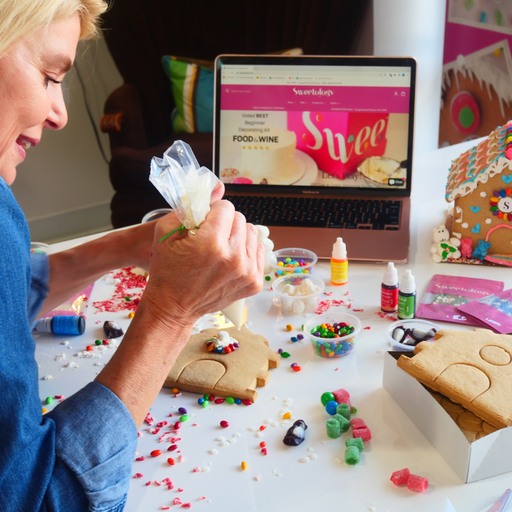 woman decorating gingerbread house kit - virtual events